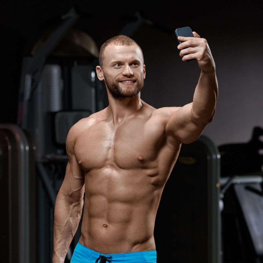 Muscular man taking a shirtless selfie